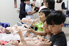 写真：実物大の胎児人形に触れる子どもたち