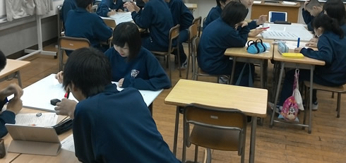 写真：各班で1台ipadを使って他の班との意見交換